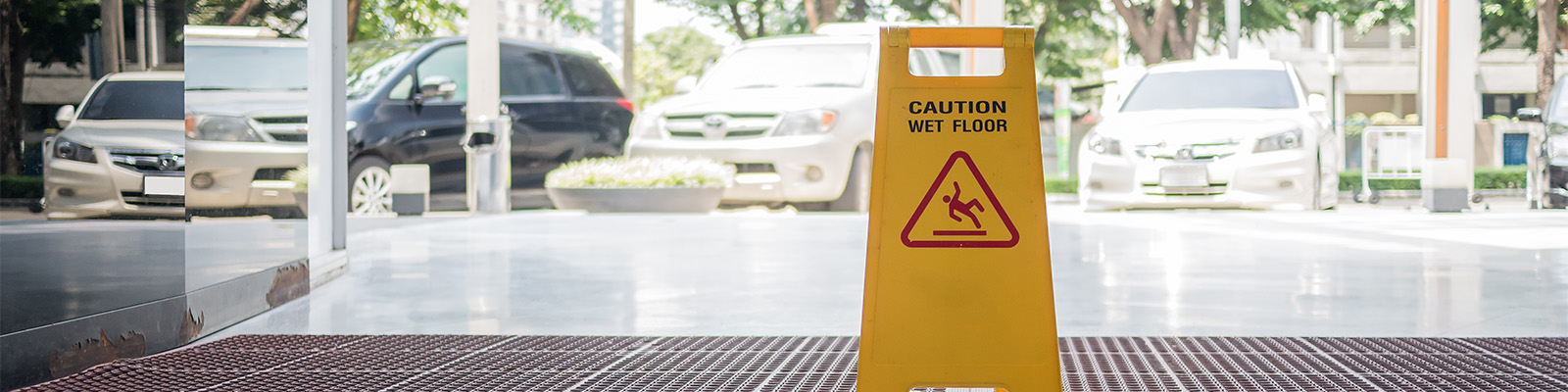 wet floor sign on the floor near an outdoor parking